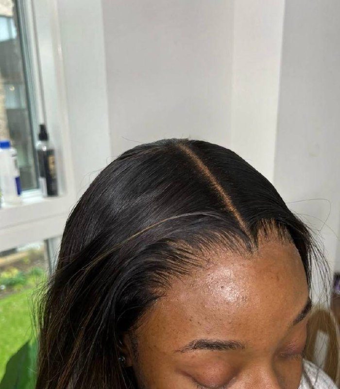Sleek dark wig installation with a centre part, styled and finished